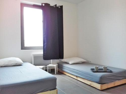 deux lits jumeaux dans une chambre avec fenêtre dans l'établissement Appartement moderne avec terrasse, parking et proche plage au Lavandou - 2 étoiles - FR-1-251-331, au Lavandou