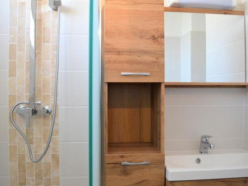 La salle de bains est pourvue d'une douche et d'une armoire en bois. dans l'établissement Appartement 3 pièces avec parking, animaux admis, Le Lavandou - FR-1-251-374, au Lavandou