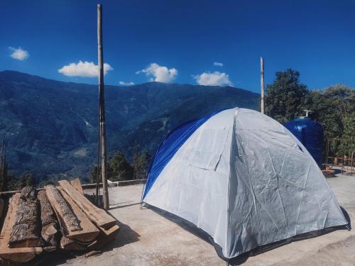uma tenda e um banco com vista para as montanhas em Prakriti Homestay em Mangpu