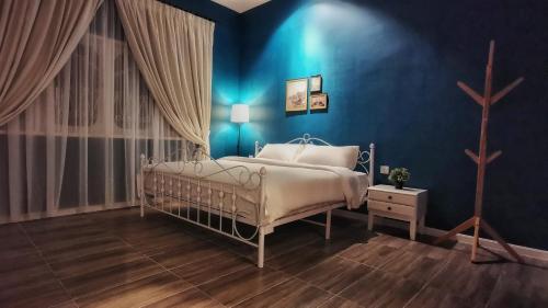 um quarto azul com uma cama e uma parede azul em IPOH AGONG HOMESTAY by ONE LIFE FOUR SEASON GUESTHOUSE em Ipoh