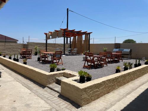 a patio with tables and chairs and a table with plants at Letlhakeng Park-Route Apartments 