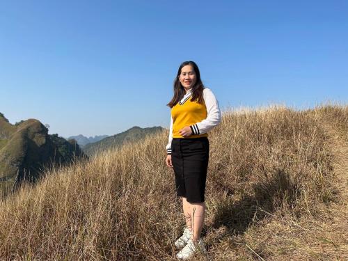 a woman standing in a field of tall grass at Trường Giang Homestay in Cao Bằng
