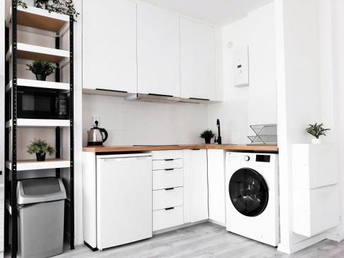 a kitchen with white cabinets and a washing machine at Wera in Kłodzko