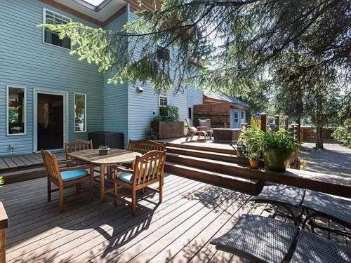 una terraza de madera con mesa y sillas en una casa en Bell In The Woods B&B en Seward