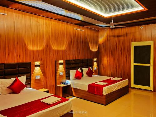 a bedroom with two beds with red pillows at Kyarki Resort in Rishīkesh