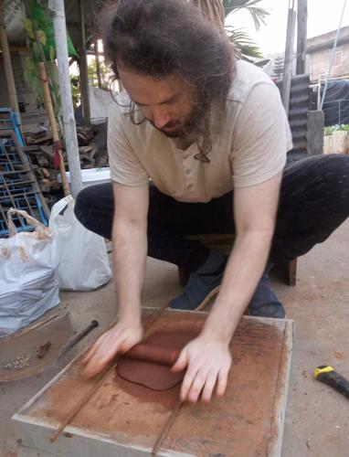 a man is working on a piece of wood at Blissful Eyrie in Guwahati