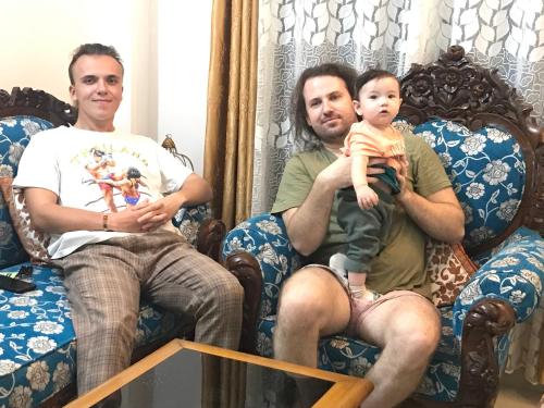 two men and a baby sitting on chairs at Blissful Eyrie in Guwahati