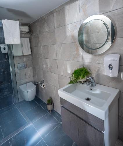 a bathroom with a sink and a mirror and a toilet at The Gate Kadıköy Downtown in Istanbul