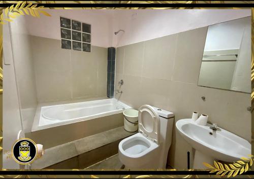 uma casa de banho com uma banheira, um WC e um lavatório. em White Knights Real em Dumaguete