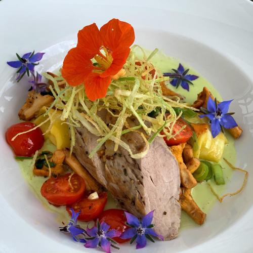 a plate of food with meat and flowers on it at Seminar- & Tagungshotel Große Ledder in Wermelskirchen