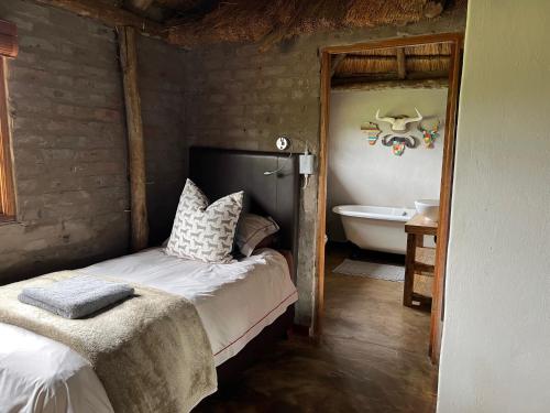 a bedroom with a bed and a bathroom with a tub at Vilagama Game Lodge in Naboomspruit