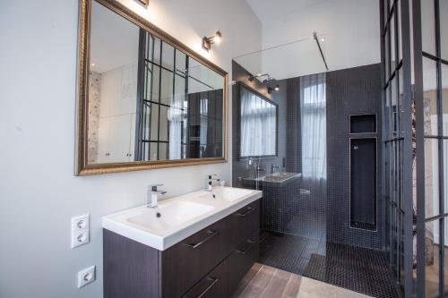 W łazience znajduje się umywalka, lustro i prysznic. w obiekcie 205m2 Penthouse with 75m2 Castle View Terrace and Barbercue - My Loft in Budapest w Budapeszcie