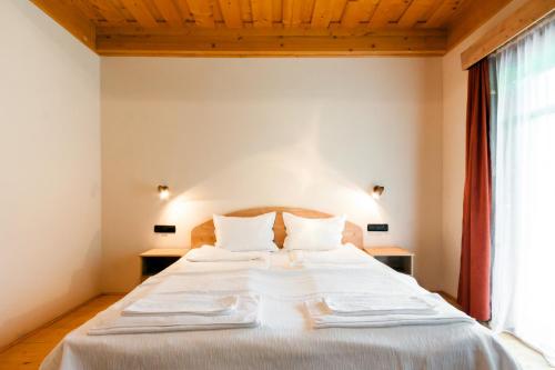 ゲオルゲニにあるPensiunea Sapte Floriのベッドルーム1室(白いシーツ付きのベッド1台、窓付)