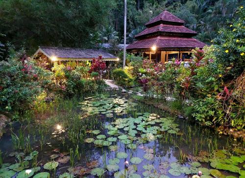 un laghetto con imbottiture di ninfee di fronte a un edificio di Sentosa Janda Baik a Kampong Sum Sum