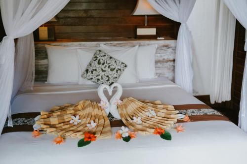 a bedroom with two beds with white pillows at Dini D'Nusa Lembongan in Nusa Lembongan