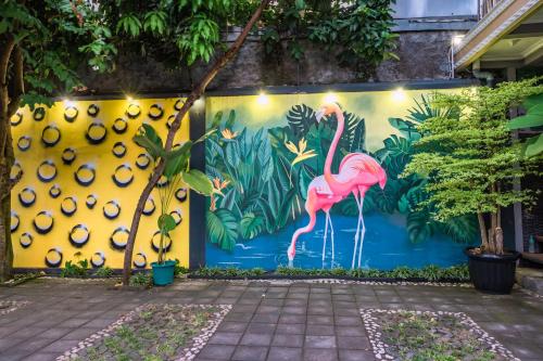 a mural of a pink flamingo on a wall at Metro Malioboro Living in Yogyakarta