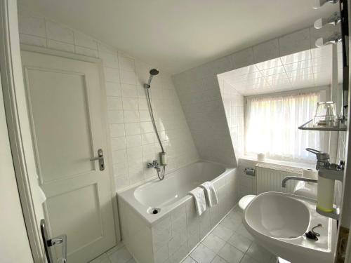 a bathroom with a tub and a toilet and a sink at Hotel Zámeček na Čeladné in Čeladná