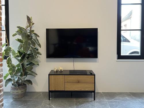 a living room with a tv on a white wall at Appartement - Centre Ville in Joigny