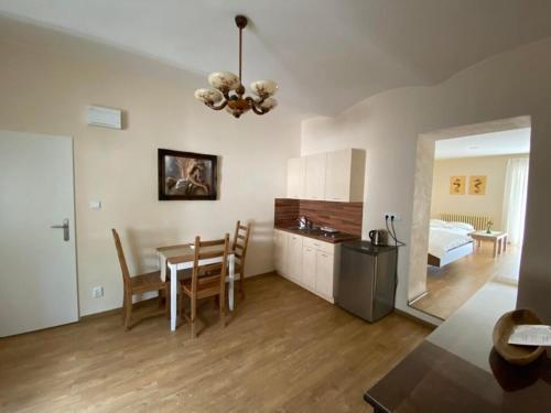 a kitchen and dining room with a table and a bedroom at Hotel Zámeček na Čeladné in Čeladná