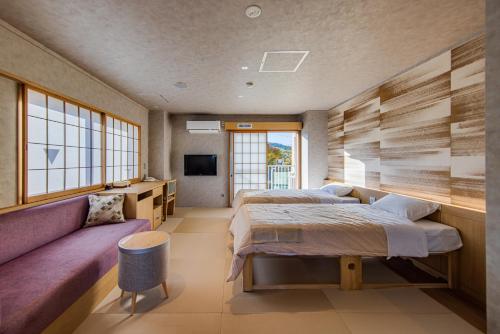 澀川市的住宿－Stay View Ikaho，一间卧室配有两张床和一张紫色沙发