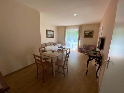 a living room with a table and chairs and a couch at Hotel Zámeček na Čeladné in Čeladná