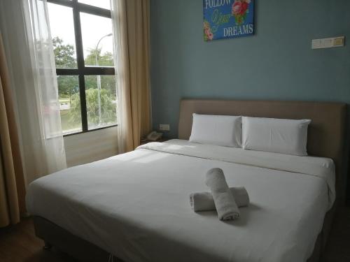 a white bed with a stuffed animal on it at CHARISMA HOTEL in Kuantan