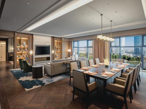 - une salle à manger et un salon avec une grande table et des chaises dans l'établissement HUALUXE Kunshan Huaqiao, an IHG Hotel - F1 Racing Preferred Hotel, à Kunshan