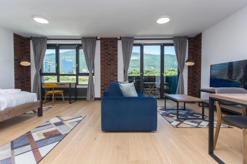 a living room with a blue couch and a table at Complex Gallery Vitosha **** in Sofia