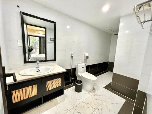 y baño con aseo, lavabo y espejo. en Sunmay Villa Tam Dao - Venuestay, en Vĩnh Phúc