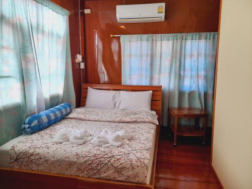 um quarto com uma cama com dois sapatos brancos em โฮมสเตย์ยายสฤษดิ์ (ซอย 17 ล่าง) em Chiang Khan