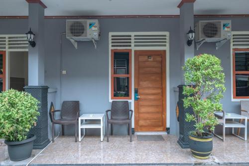 a front door of a house with chairs and a table at Metro Malioboro Living in Yogyakarta