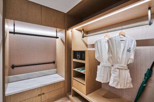 un vestidor con una camisa blanca colgando de ganchos en Holiday Inn & Suites Kunshan Huaqiao, an IHG Hotel - F1 Racing Preferred Hotel, en Kunshan