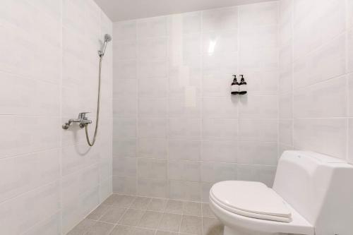 a white bathroom with a toilet and a shower at Cordelia Hotel in Seogwipo
