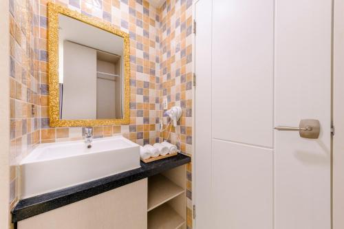 a bathroom with a sink and a mirror at Cordelia Hotel in Seogwipo