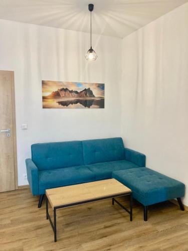 a blue couch in a living room with a coffee table at Tilia apartments Březová in Březová