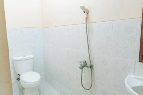 a bathroom with a shower with a toilet and a sink at Metro Malioboro Living in Yogyakarta