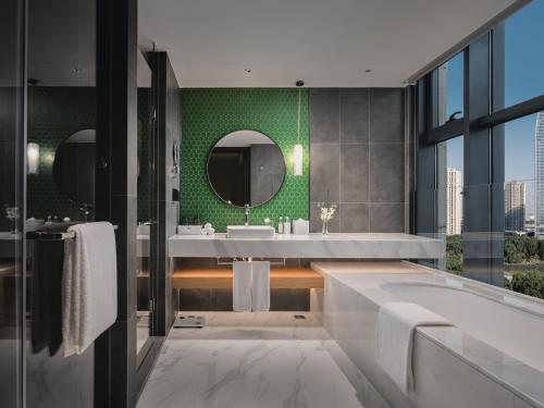 a bathroom with a tub and a green wall at Holiday Inn & Suites Kunshan Huaqiao by IHG - F1 Racing Preferred Hotel in Kunshan