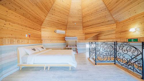 a large bedroom with a bed in a wooden ceiling at Geojerowa Pension in Geoje 