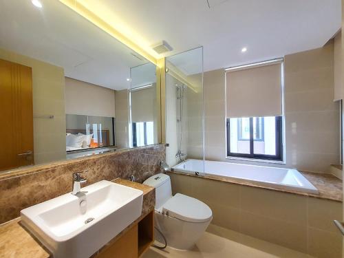 y baño con lavabo, aseo y bañera. en Wyndham Cam Ranh Villa 1412 en Cam Lâm