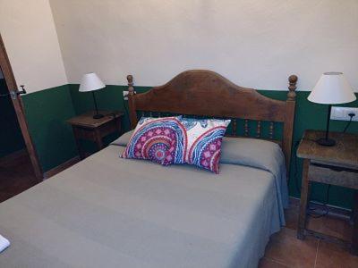 1 dormitorio con 1 cama y 2 mesas con lámparas en Cabaña rural La Dehesa, en Riópar