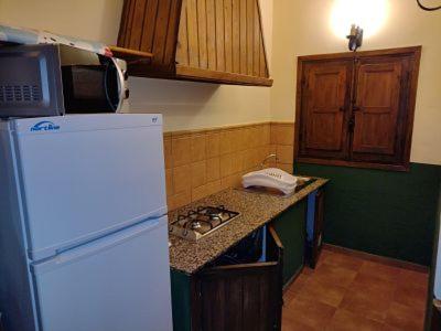 cocina con nevera y encimera en Cabaña rural La Dehesa, en Riópar