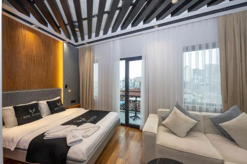Un dormitorio con una cama grande y un sofá. en Roe Suite Hotel - TAKSIM, en Estambul