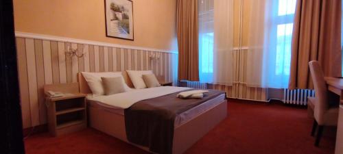 a hotel room with a bed and a window at Hotel Vojvodina in Novi Sad
