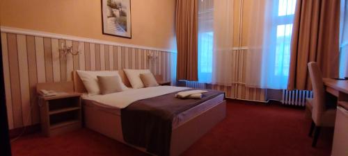 a hotel room with a bed with a phone on it at Hotel Vojvodina in Novi Sad
