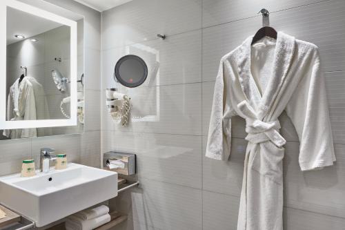 a bathroom with a white robe hanging on a wall at Mercure Paris 15 Porte de Versailles in Paris