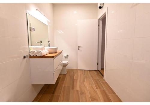 a white bathroom with a sink and a toilet at Dream House Tiberias in Tiberias