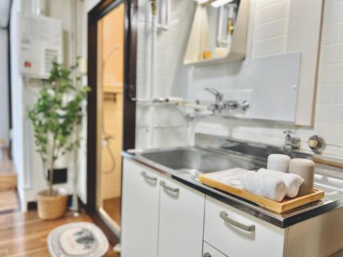 a kitchen with a sink and a counter with towels at attomi hostel in Sapporo