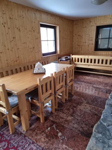 a dining room with a wooden table and chairs at Chata Pod Velkou Racou in Oščadnica