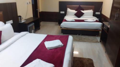 a hotel room with two beds with towels on them at Marina Group of hotel Mountain View Free Parking-cricket stadium 9 km-Mcleodganj 2 km- Bhagsunag 4 in Dharamshala