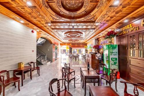 un restaurant avec des tables et des chaises en bois et un plafond dans l'établissement Cao Gia Hải, à Hô-Chi-Minh-Ville